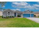 Inviting home exterior with a well-maintained lawn and blue double garage doors at 3769 Fiano Dr, Port Orange, FL 32129
