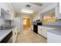 Kitchen with white cabinets, black appliances, and tile floor at 5025 E Lake Mary Blvd, Sanford, FL 32771