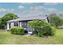 White house with black window trim and screened porch at 245 W Ocala St, Umatilla, FL 32784