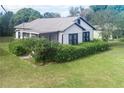 White house with black window trim and lush green hedges at 245 W Ocala St, Umatilla, FL 32784