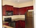 Modern kitchen with dark wood cabinets and granite countertops at 1321 Arbor Vista Loop # 209, Lake Mary, FL 32746