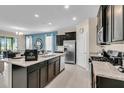 Open concept kitchen with large island and stainless steel appliances at 5288 Oakbourne Ave, Davenport, FL 33837