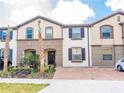 Two-story townhome with attractive landscaping and a two-car driveway at 8890 Geneve Ct, Kissimmee, FL 34747