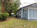 Gray house with red roof, landscaped lawn, and a stop sign on the street at 1037 S Adelle Ave, Deland, FL 32720