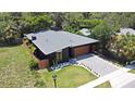 Stylish home, gray roof, wood garage door, and lush green surroundings at 737 N Capen Ave, Winter Park, FL 32789