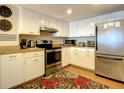 Galley kitchen with stainless steel appliances and wood floors at 1513 Ocean Shore Blvd # 9E, Ormond Beach, FL 32176