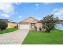 House exterior view showcasing the front yard and driveway at 165 Captain Hook Way, Davenport, FL 33837