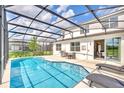 Inviting pool area with screened enclosure, lounge chairs, and a grilling station at 330 Ballo Dr, Kissimmee, FL 34746