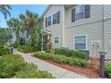 Townhouse exterior with walkway and manicured hedges at 2958 Lucayan Harbour Cir # 108, Kissimmee, FL 34746