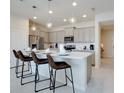Modern kitchen with gray cabinets, quartz countertops, and island with seating at 8916 Sydney Ave, Kissimmee, FL 34747