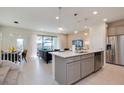 Open concept kitchen with island, stainless steel appliances, and view into living room at 8916 Sydney Ave, Kissimmee, FL 34747