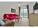 Living room with red couch, wood coffee table, and access to a balcony at 1375 Tuscana Ln # 1308, Davenport, FL 33896