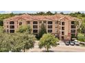 Three-story building with tile roof, ample parking, and lush surroundings at 1375 Tuscana Ln # 1308, Davenport, FL 33896