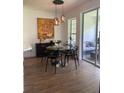 Bright dining area with glass table, four black chairs, and access to a relaxing patio at 7429 Green Tree Dr # 96, Orlando, FL 32819