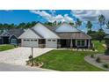 Modern farmhouse exterior with three-car garage at 6437 Sw 180Th Cir, Dunnellon, FL 34432