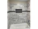 Renovated bathroom with gray marble tile and a new bathtub at 824 Camargo Way # 106, Altamonte Springs, FL 32714