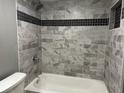 Updated bathroom with grey tile, a bathtub, and a shower at 822 Camargo Way # 101, Altamonte Springs, FL 32714