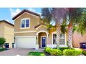 Two-story house with a two-car garage and landscaped front yard at 8920 Bengal Ct, Kissimmee, FL 34747