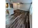 Living room with dark wood-look floors and access to kitchen at 1027 S Hiawassee Rd # 2313, Orlando, FL 32835