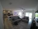 Open-concept living room, kitchen, and dining area with gray sectional sofa at 964 Avenal Ln, Davenport, FL 33837