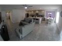 Open-concept living space with gray sectional sofa and adjoining kitchen at 964 Avenal Ln, Davenport, FL 33837