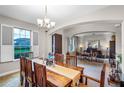 Formal dining room with wood table and access to living room at 15465 Heron Hideaway Cir, Winter Garden, FL 34787
