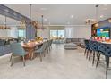 Spacious dining room with modern chandelier, large table, and access to a balcony at 2126 Lelani Cir, Davenport, FL 33897