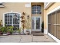 Front entrance with a white door, decorative glass, and landscaping at 2570 Amaya Ter, Lake Mary, FL 32746