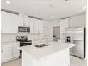 Modern kitchen with white cabinets, quartz countertops, and stainless steel appliances at 5953 Catamaran Ave, Haines City, FL 33844