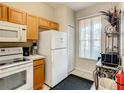 Bright kitchen features white appliances and wood cabinets at 702 Calabria Ave, Davenport, FL 33897