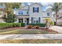Two-story home with light gray siding, black shutters, and manicured landscaping at 9149 Outlook Rock Trl, Windermere, FL 34786