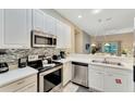 Modern kitchen with stainless steel appliances and white cabinets at 806 Lucaya Loop, Davenport, FL 33897