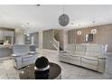 Open living room and kitchen with white sofas and modern light fixtures at 8911 Stinger Dr, Champions Gate, FL 33896