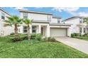 Two-story home with gray and white exterior and landscaping at 320 Ballo Dr, Kissimmee, FL 34746