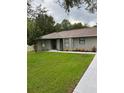 Newly renovated home with gray exterior, modern landscaping, and a welcoming front entrance at 19 Pine Court Loop, Ocala, FL 34472