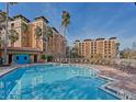 Resort-style pool with lounge chairs, surrounded by palm trees at 12538 Floridays Resort Dr # 401-C, Orlando, FL 32821