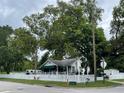 White house with green awning, white picket fence, and a large tree in the front at 113 Gem Lake Dr, Maitland, FL 32751
