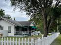 White house with a green awning, white picket fence, and a spacious yard at 113 Gem Lake Dr, Maitland, FL 32751