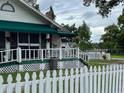 White house with green awning, white picket fence, and a porch with railing at 113 Gem Lake Dr, Maitland, FL 32751