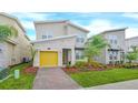 Modern two-story home with a yellow garage door and landscaped front yard at 751 Drop Shot Dr, Davenport, FL 33896