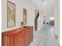 Bright entryway with tile flooring, wooden console table, and two mirrors at 751 Drop Shot Dr, Davenport, FL 33896