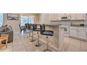 Modern kitchen with granite countertops, white cabinets, and breakfast bar with seating at 742 Orange Cosmos Blvd, Davenport, FL 33837