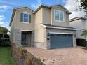 Two-story house featuring stone accents and a two-car garage at 7405 Marker Ave, Kissimmee, FL 34747
