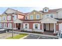 Three-story townhouses with red and beige exterior, and landscaping at 7529 Sunflower Cir, Kissimmee, FL 34747