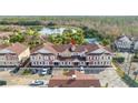 Aerial view of townhouses with a community lake and tennis court nearby at 7529 Sunflower Cir, Kissimmee, FL 34747