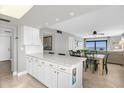 White kitchen cabinets, granite countertops, open to dining area at 4445 S Atlantic Ave # 606, Ponce Inlet, FL 32127