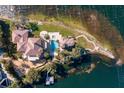 Bird's eye view of a waterfront estate, showcasing the house and pool at 4200 Down Point Ln, Windermere, FL 34786