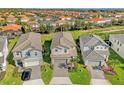 Three-house community view showcasing homes with gray roofs and two-car garages at 7259 Oakmoss Loop, Davenport, FL 33837