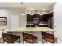 Modern kitchen featuring a large island with seating and stainless steel appliances at 7538 Sunville Ave, Kissimmee, FL 34747