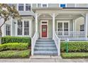 Front porch of a two-story house with a red door and white railings at 902 Towhee Ct, Celebration, FL 34747